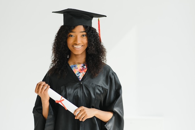 Estudiante de posgrado afroamericano alegre con diploma en la mano