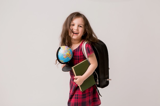 estudiante de primer grado con libros y un globo sonriendo