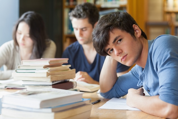 Estudiante que se inclina en la tabla que parece cansada