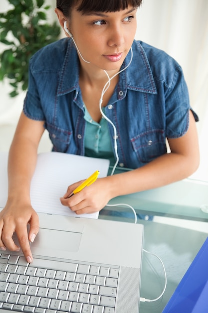 Foto estudiante que mira lejos mientras hace su tarea