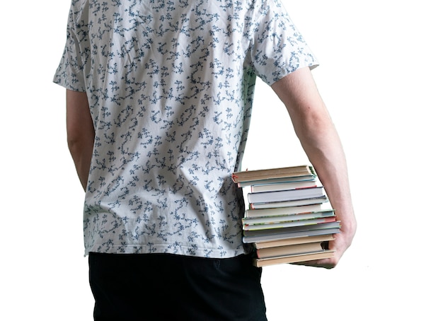 Un estudiante que sostiene la pila de libros, lleva libros de texto de papel pesado, concepto de motivación, fondo blanco aislado