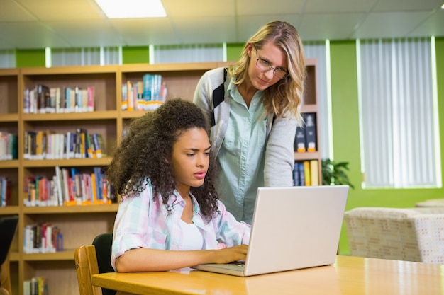 Estudiante recibiendo ayuda del tutor en la biblioteca