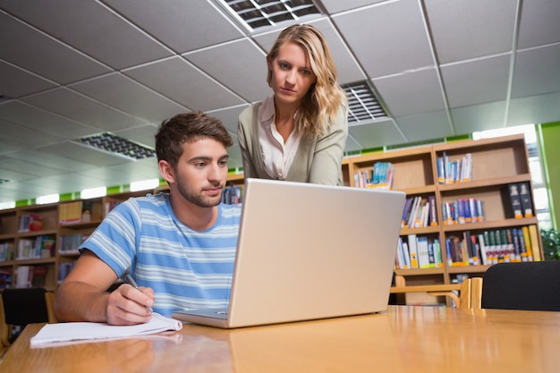 Estudiante recibiendo ayuda del tutor en la biblioteca