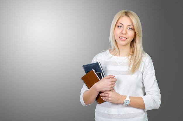 Estudiante rubia con pila de libros