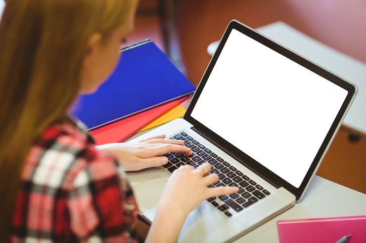 Foto estudiante rubia que usa la computadora portátil durante la clase