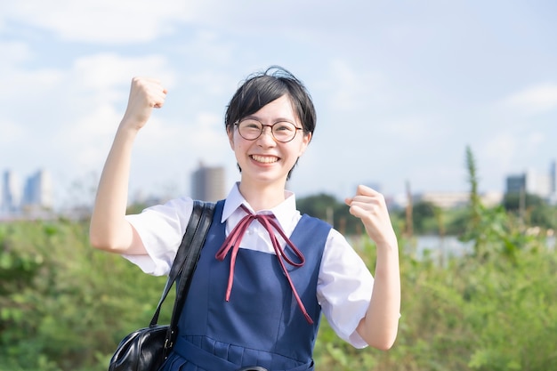 Estudiante de secundaria femenina posando animando con una sonrisa al aire libre