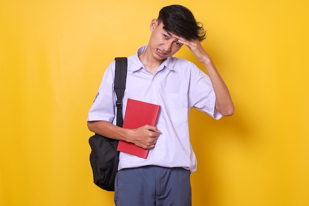 Estudiante de secundaria en uniforme sintiendo dolor de cabeza y cansado