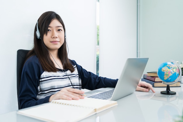 Estudiante sentado en la sala y aprendiendo en línea