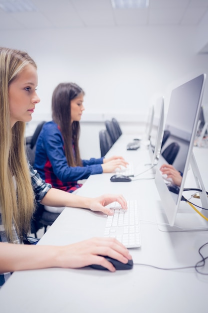 Estudiante serio trabajando en la computadora en la universidad