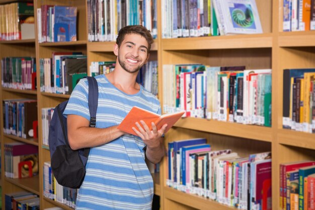 Estudiante sonriendo a la cámara en la biblioteca