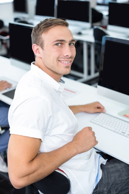 Estudiante sonriendo a la cámara en clase de informática