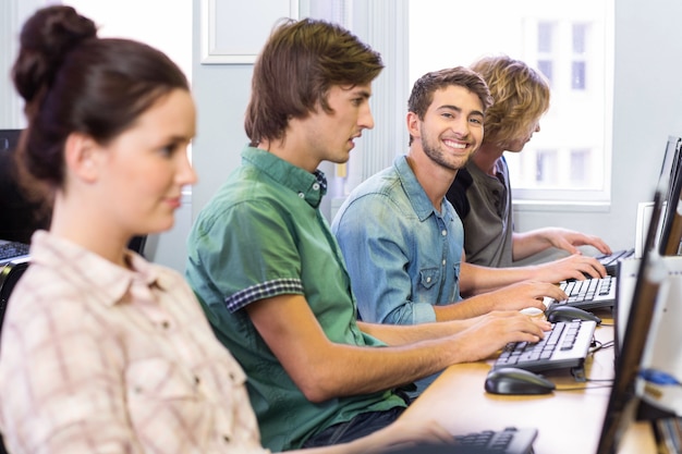 Estudiante sonriendo a la cámara en clase de informática