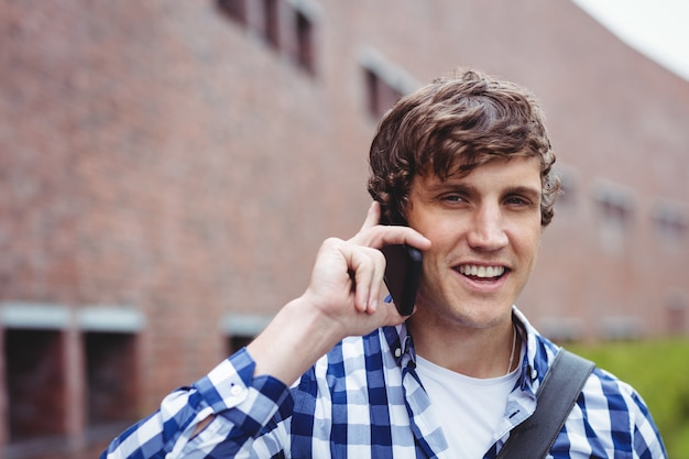 Estudiante sonriente hablando por teléfono móvil