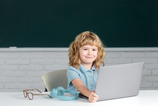 Un estudiante sonriente que usa una computadora portátil en la clase de la escuela