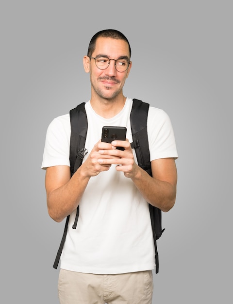 Estudiante sorprendido apuntando y usando su teléfono móvil