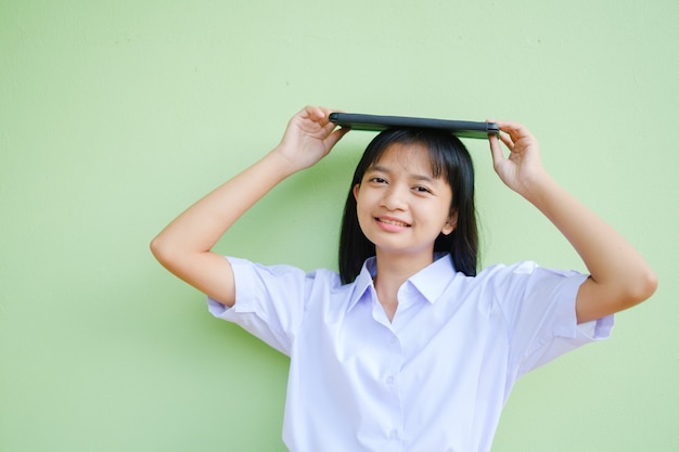 El estudiante tiene una computadora portátil con pared verde.