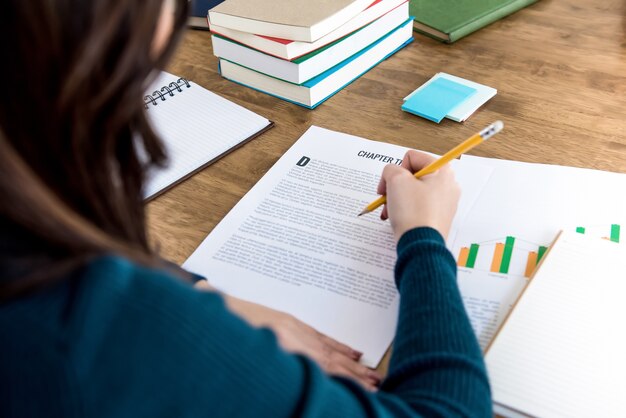 Estudiante de la universidad femenina leyendo información en papel