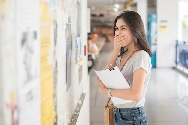 Una estudiante universitaria es emocionante con el informe del examen