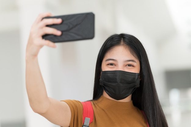 Una estudiante universitaria con un teléfono tomando un selfie en la universidad, Regreso a la escuela,