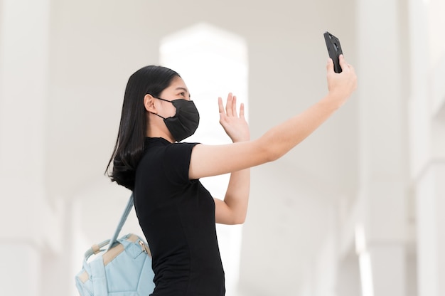 Una estudiante universitaria con un teléfono tomando un selfie en la universidad, Regreso a la escuela,