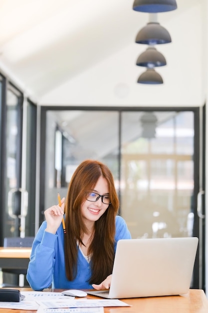 Una estudiante universitaria usa una computadora para acceder a Internet para aprender en línea y hacer negocios en línea Concepto de aprendizaje en línea