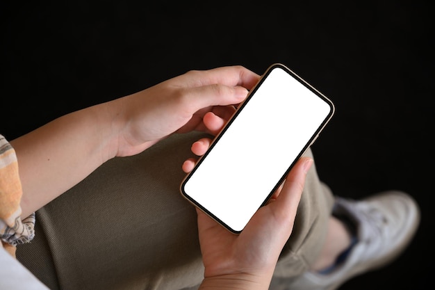 Estudiante universitaria usando su teléfono móvil buscando algo en el sitio web Pantalla blanca del teléfono