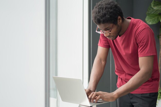 Estudiante universitario africano cansado vuelve a la escuela; retrato de estudiante masculino nerd agotado que estudia mucho en la educación superior o universitaria, concepto de regreso a la escuela; Modelo de hombre adulto joven africano