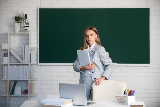 Estudiante universitario femenino sosteniendo el libro en el aula preparándose para el examen