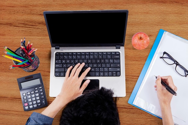 Estudiante universitario haciendo la tarea en el escritorio.