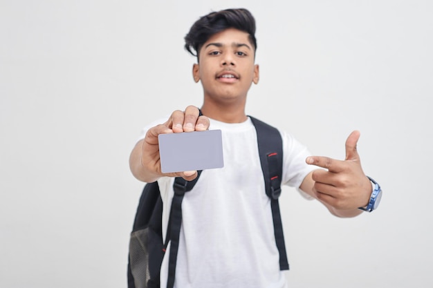 Estudiante universitario indio que muestra la tarjeta en el fondo blanco.