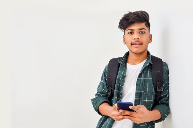 Estudiante universitario indio con smartphone sobre fondo blanco.