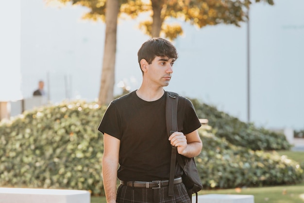 Estudiante universitario joven caminando con bolsa. Estudiante en el campus de la escuela secundaria que parece muy preocupado por los exámenes. Copie el espacio. Estudiante de estudios empresariales durante un año de maestría en intercambio