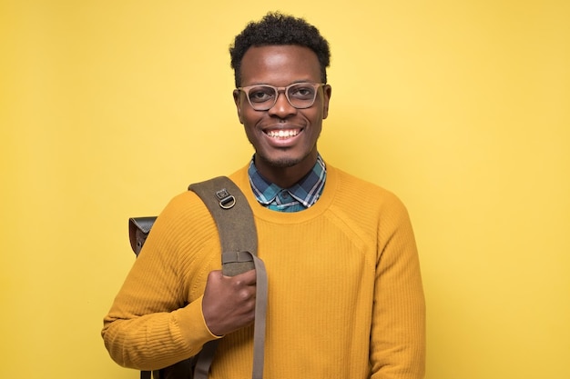 Estudiante universitario con mochila y sonriendo contento de estudiar