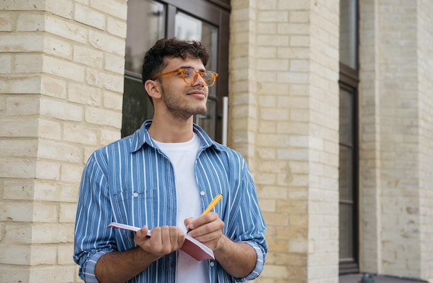 Estudiante universitario que estudia preparación para exámenes tomando notas en el concepto de educación del campus