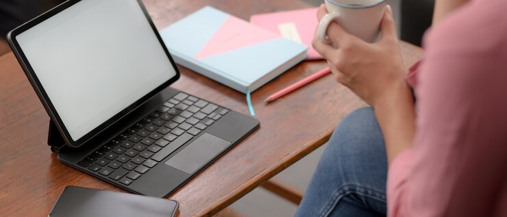 Foto estudiante universitario toma un descanso con un café mientras estudia en línea con una tableta simulada en la sala de estar