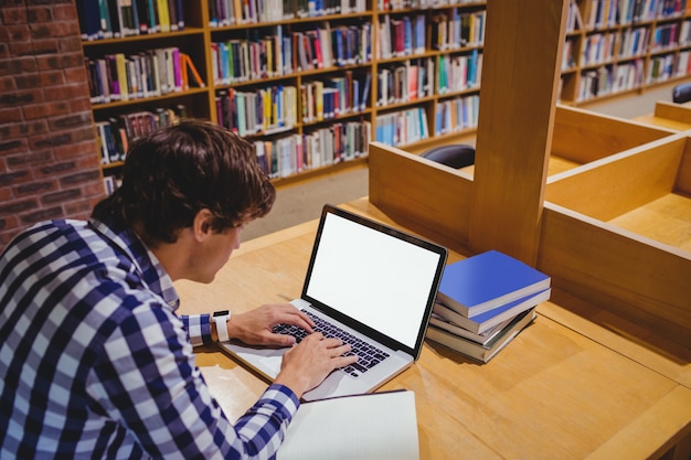 Estudiante usando una computadora portátil en la biblioteca