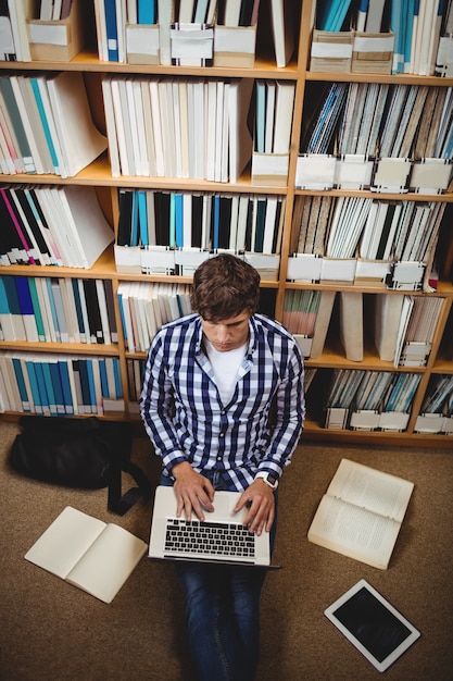 Estudiante usando una computadora portátil en la biblioteca