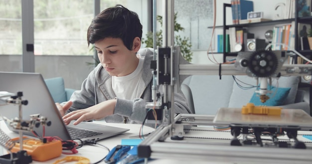 Foto estudiante usando una impresora 3d en casa