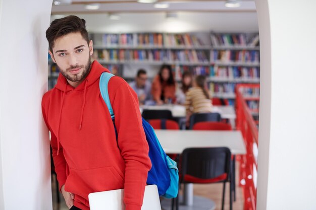 Foto el estudiante utiliza una computadora portátil y una biblioteca escolar