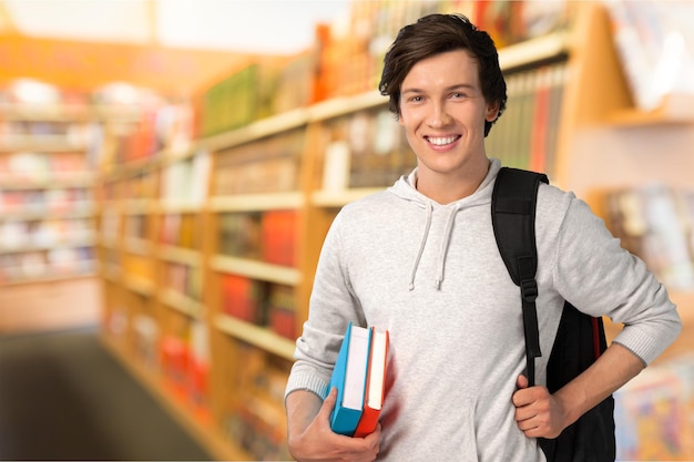 Foto estudiante varón con mochila en el fondo