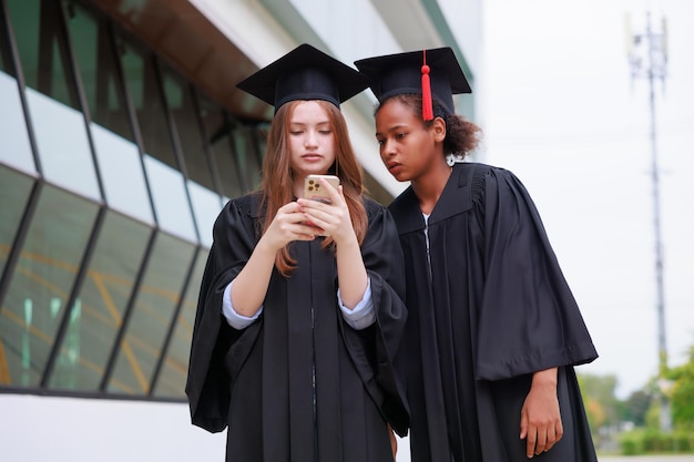 Estudiante vistiendo bata y haciendo fotos con un teléfono inteligente graduándose Feliz éxito y celebración de graduados Felicitaciones