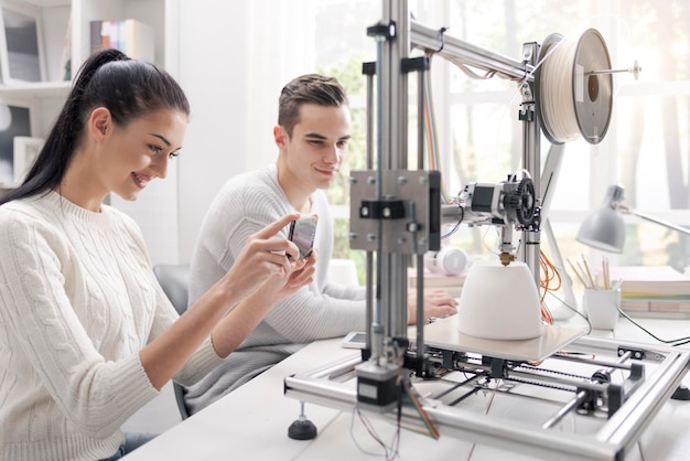 Estudiantes académicos usando una impresora 3D en el laboratorio