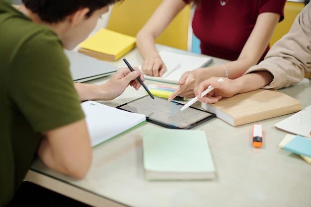 Estudiantes apuntando a la computadora de la tableta