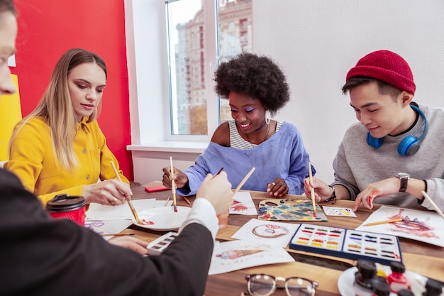 Estudiantes de arte. Dos talentosos y creativos estudiantes de arte pintando juntos en la clase.