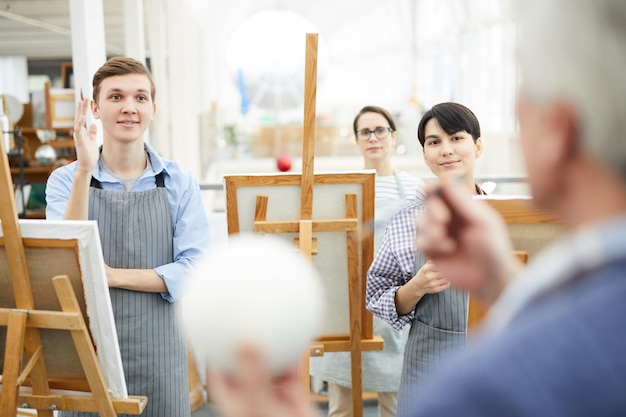 Estudiantes de arte escuchando en clase