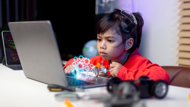 Los estudiantes de Asia aprenden en casa codificando autos robot y cables de placas electrónicas en STEM STEAM matemáticas ingeniería ciencia tecnología código informático en robótica para niños concepto