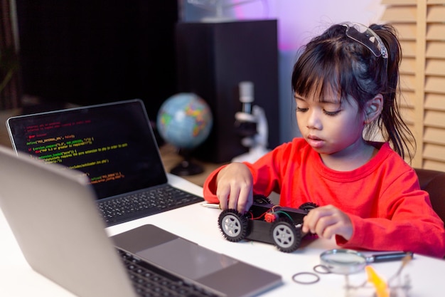 Los estudiantes de Asia aprenden en casa codificando autos robot y cables de placas electrónicas en STEM STEAM matemáticas ingeniería ciencia tecnología código informático en robótica para niños concepto