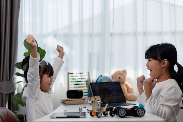 Los estudiantes de Asia aprenden en casa codificando autos robot y cables de placas electrónicas en STEM STEAM matemáticas ingeniería ciencia tecnología código informático en robótica para niños concepto