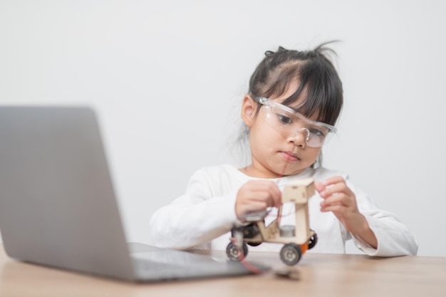 Los estudiantes de Asia aprenden en casa codificando autos robot y cables de placas electrónicas en STEM STEAM matemáticas ingeniería ciencia tecnología código informático en robótica para niños concepto