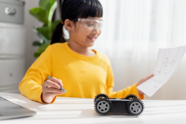 Los estudiantes de Asia aprenden en casa codificando autos robot y cables de placas electrónicas en STEM STEAM matemáticas ingeniería ciencia tecnología código informático en robótica para niños concepto